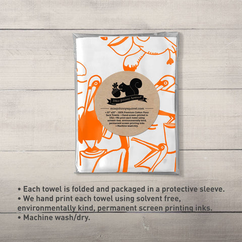Packaged towel with orange and white design on a wooden surface