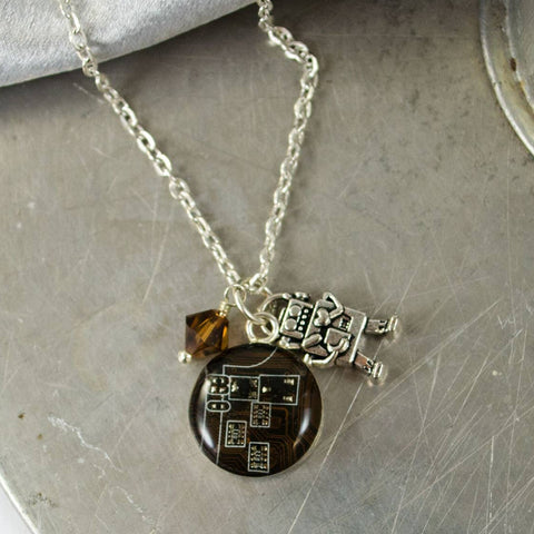 Necklace with a round pendant and a small square charm on a textured surface