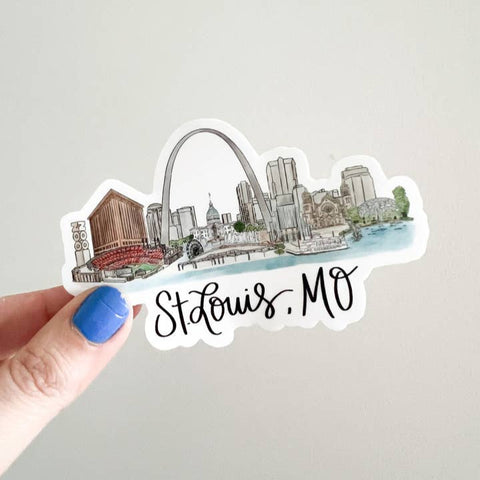 St. Louis, MO sticker held by a hand on a light gray background