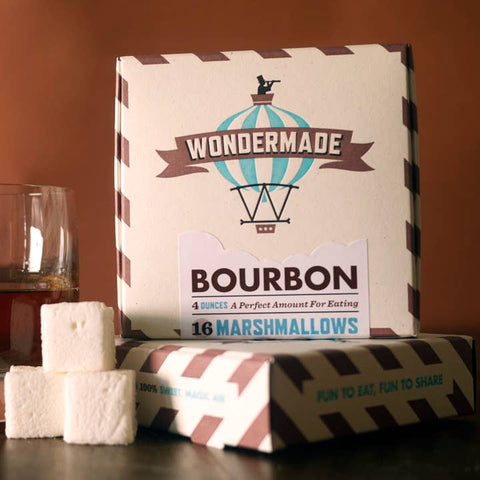 Box of Wondermade Bourbon marshmallows with marshmallows on a wooden surface.