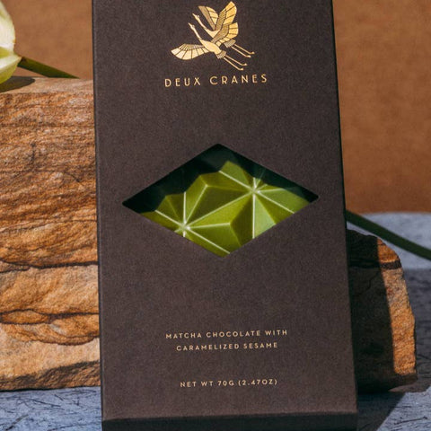 Deux Cranes matcha chocolate bar packaging on a wooden surface