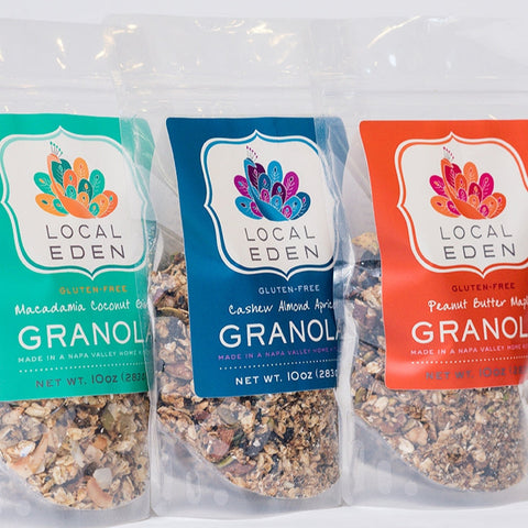 Three packages of Local Eden granola in different flavors on a white background