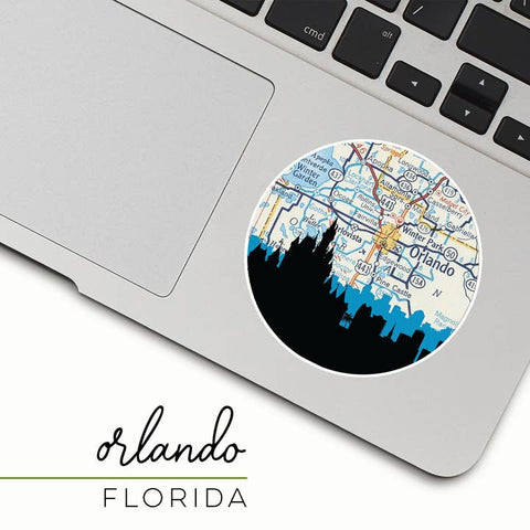Laptop with a round sticker featuring a map of Orlando, Florida, on a white background.