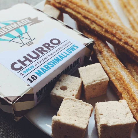Box of marshmallows labeled 'Churro' next to churros on a white surface