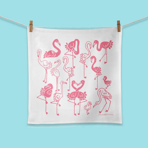 White towel with pink flamingo pattern hanging on a clothesline against a blue background