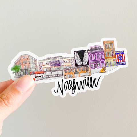 Sticker with Nashville-themed design held by a hand on a light gray background