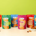 Assorted bags of organic snacks on a light surface with a green background