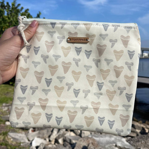 Person holding a pouch with ice cream cone pattern against a natural background