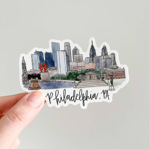 Sticker of Philadelphia skyline held by a hand on a light gray background