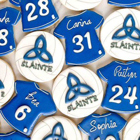 Cookies shaped like blue sports jerseys with names and numbers on a white background