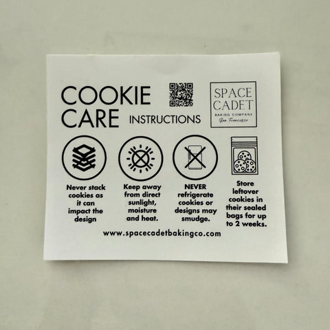 Sheet of cookie care instructions with Space Cadet Baking Company branding on a gray background