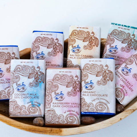 Assorted chocolate bars in decorative packaging on a wooden tray
