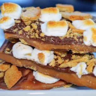 Stack of graham cracker toffee with marshmallows on a white plate