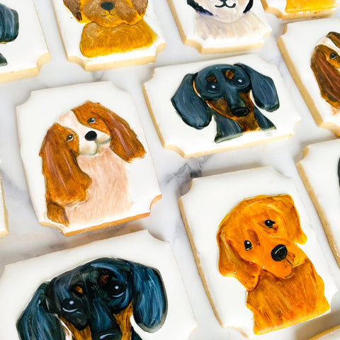 Decorative cookies shaped like dogs on a white surface