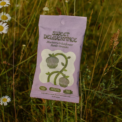 Sweet Deliverance granola packet in a field with wildflowers