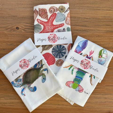 Set of paper products with sea-themed designs on a wooden surface