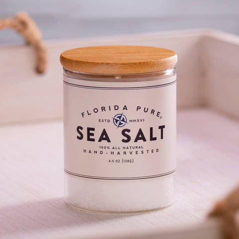 Jar of Florida Pure Sea Salt with a wooden lid on a light background