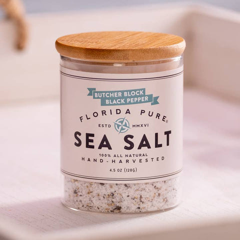 Jar of Florida Pure Sea Salt with a wooden lid on a light background