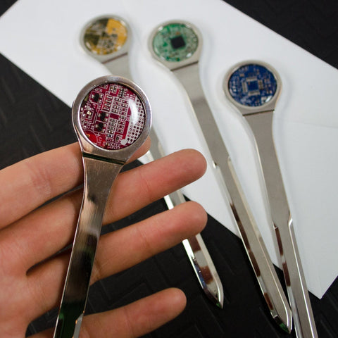 Metallic spoons with electronic components on a white surface