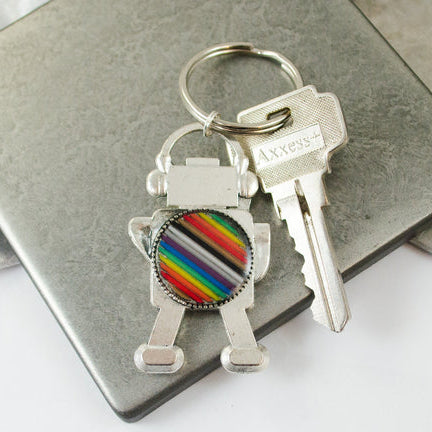 Keychain with rainbow design attached to a set of keys on a metallic surface.