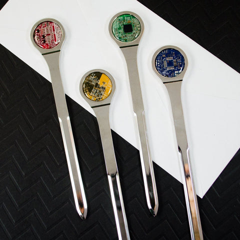 Set of four forks with electronic components on a white napkin against a black textured background
