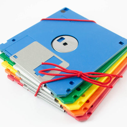 Stack of colorful floppy disks tied with a red string on a white background