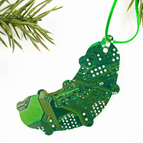 Christmas ornament shaped like a green caterpillar made of circuit board material, hanging on a branch.
