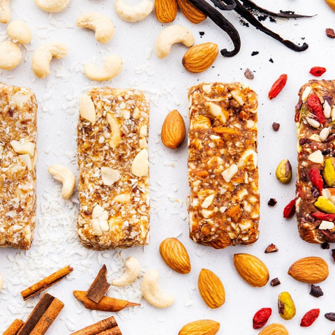 Four granola bars with various nuts and seeds on a light background