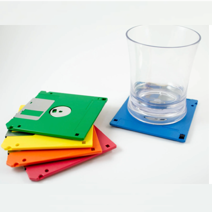 Colorful floppy disc coasters with a glass on a white background
