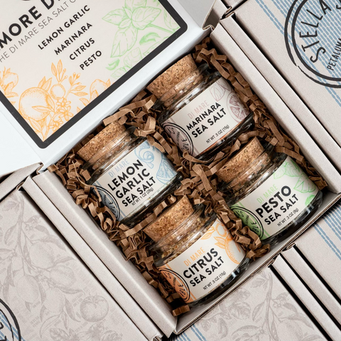 Three jars of sea salt in a decorative box with 'More Di Mano' branding.