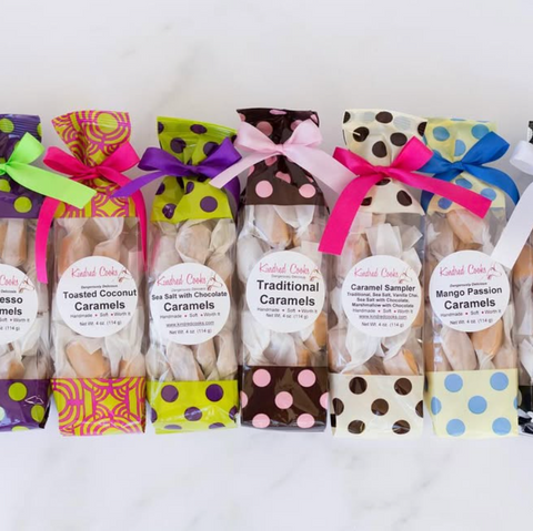 Assorted caramel packages with colorful ribbons on a white background