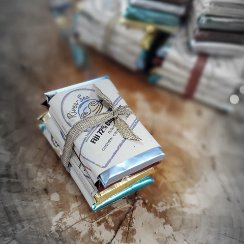 Small stack of books with decorative covers on a textured surface