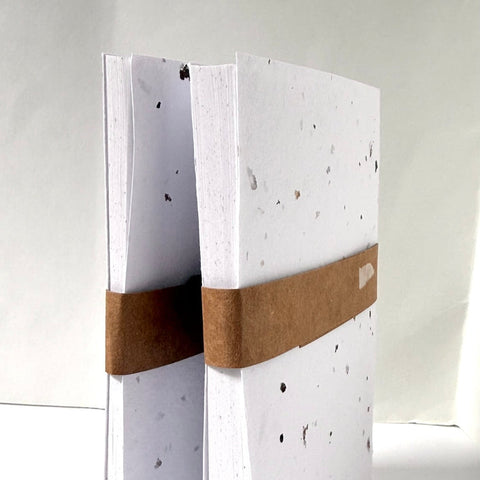 White notebook with a brown leather strap on a white background