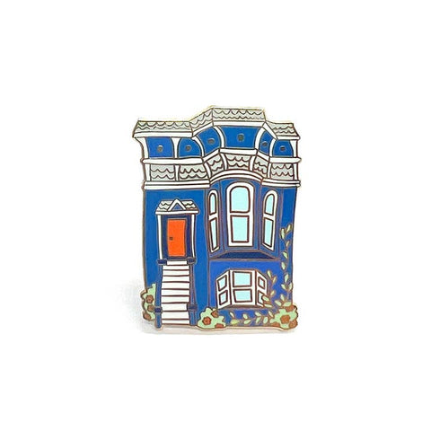 Pin of a blue house with a red door on a white background