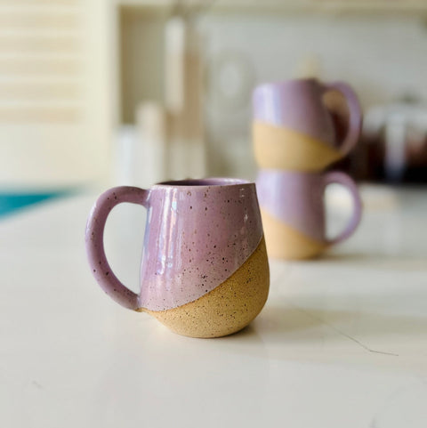 Two ceramic mugs with a gradient design on a light surface.