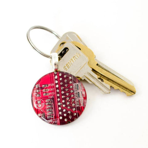 Keychain with a red circuit board design and a key on a white background