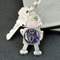Keychain with robot design featuring a purple circuit board on a gray surface.