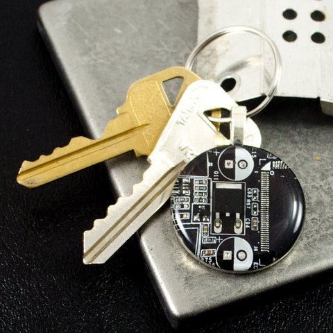 Keychain with electronic component and keys on a metallic surface