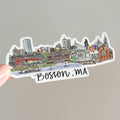 Sticker of Boston, MA skyline held by a hand on a gray background