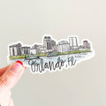 Sticker of Orlando, FL skyline held by a hand on a light gray background
