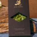 Deux Cranes matcha chocolate bar packaging on a wooden surface