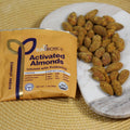 SunBiotics Activated Almonds packaging with almonds on a marble slab on a woven mat.