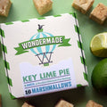 Box of Wondermade Key Lime Pie marshmallows with marshmallows and a lime on a green background