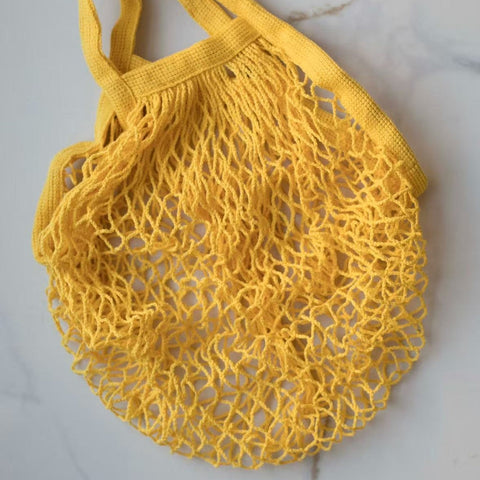 Yellow mesh bag on a light gray background