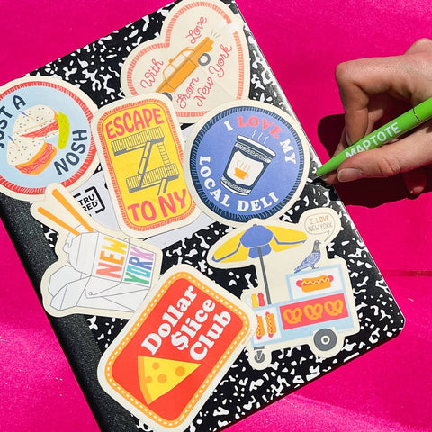Notebook with colorful stickers on a pink background