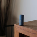 Blue cylindrical container on a wooden surface with a neutral background
