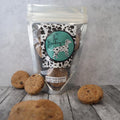Dog cookies with a branded packaging on a wooden surface