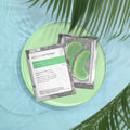 Green tea eye patches on a green plate with palm leaves in the background