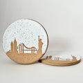 Two ceramic coasters with city skyline design on a white background