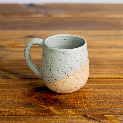 Speckled ceramic mug on a wooden surface
